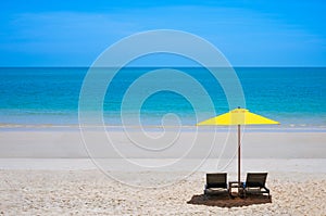 Two beach chairs on white sand beach with tropical seascape. Summer holiday travel background