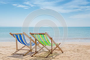 Two beach chairs on the white sand with blue sky and summer sea background. Summer, Vacation, Travel and Holiday concept
