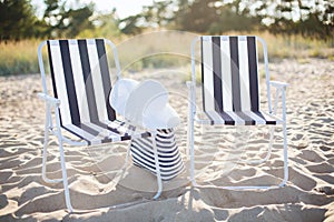 Two beach lounges with beach bag and white hat
