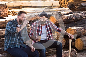 two bearded loggers sitting with disposable cups of coffee photo