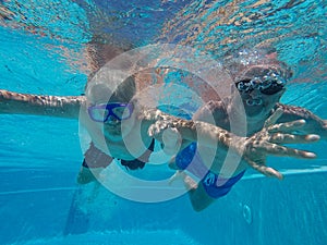 Two bearded men diving in swimming pool learning to snorkeling. Caucasian senior couple of men floating in the water