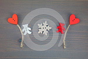 Two bears with balloons-hearts and snowflake on grey wooden background.