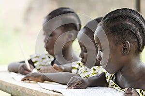 Two beautiful African girls and one African boy reading and writ photo