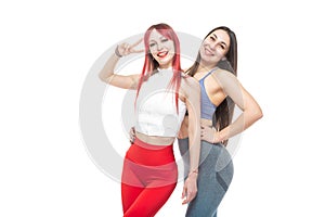 Two beautiful, athletic, slim and cheerful female friends are smiling. Lifestyle concept with sports and gym. Isolated