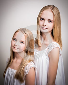 Two Beautiful Blond Teenage Girls Dressed in White.