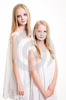 Two Beautiful Blond Teenage Girls Dressed in White.