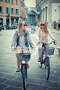 Two beautiful blonde women shopping on bike