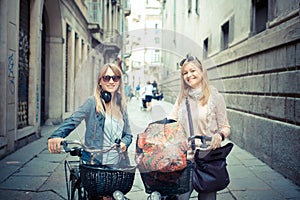 Two beautiful blonde women shopping on bike