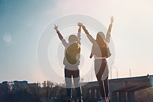 Two beautiful cool teenage girls 15-16 years old, best friends having fun, with their hands up