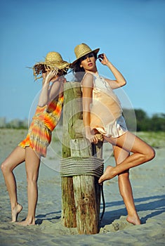 Two beautiful fashion models enjoy the beach