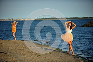 Two beautiful fashion models enjoy the beach