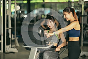 Two fitness woman working out in gym together.