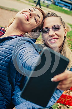 Two beautiful friends funny selfie on a tablet