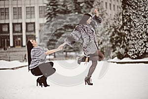 Two beautiful girlfriends hugging and smiling outdoors in winter. Two young female friends portrait closeup. Retouched, natural