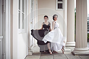 Two beautiful girls in black and white long dresses