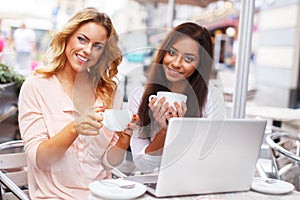 Two beautiful girls in cafe with laptop