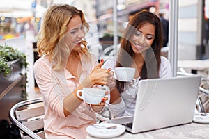 Two beautiful girls cups and laptop