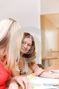 Two beautiful girls discuss the magazine photo