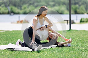 two beautiful girls do exercises outdoors in the park