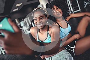 Two beautiful girls in the gym do selfie. Sports, fitness, boxing, gym