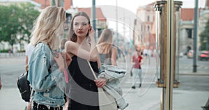 Two beautiful girls looking at clothes in a shop window.