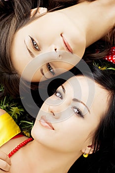 Two beautiful girls lying on the grass.