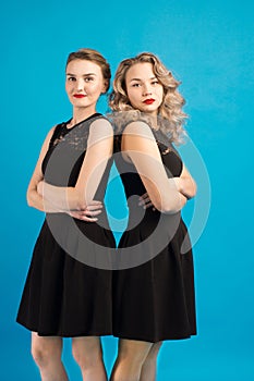 Two beautiful girls in the same black dress