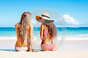 Two Beautiful Girls Sitting on the Beach