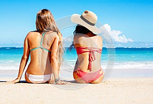 Two Beautiful Girls Sitting on the Beach