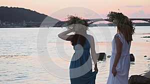 Two beautiful girls are talking on the river bank