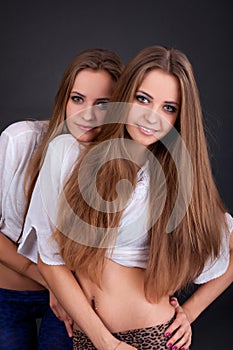 Two beautiful girls twins, isolated on black
