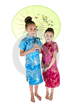 Two beautiful girls wearing Asian dresses under umbrella