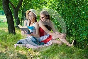 Two Beautiful happy smiling young women reading