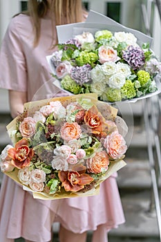 Two beautiful luxury bouquet of mixed flowers in woman hand. the work of the florist at a flower shop. A small family