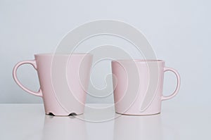 Two beautiful pink cups of cappuccino with latte art on table