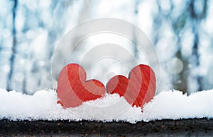 Two beautiful romantic vintage red hearts together on a white snow winter background. Love and St. Valentines Day concept