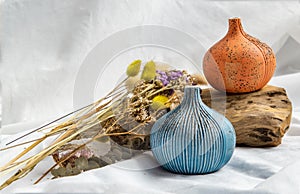 Two beautiful small ceramic vases with wooden logs on white background