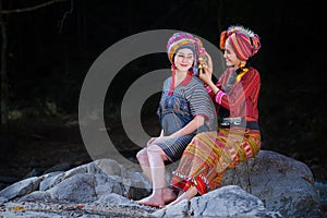 Two Beautiful Thai women smile in karen suit spinning thread on