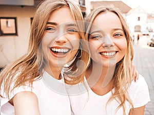 Two beautiful trendy girls posing in the street