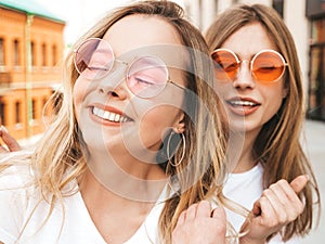 Two beautiful trendy girls posing in the street