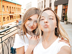 Two beautiful trendy girls posing in the street