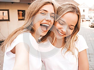 Two beautiful trendy girls posing in the street