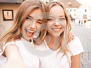 Two beautiful trendy girls posing in the street