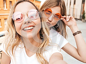 Two beautiful trendy girls posing in the street