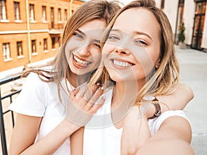 Two beautiful trendy girls posing in the street