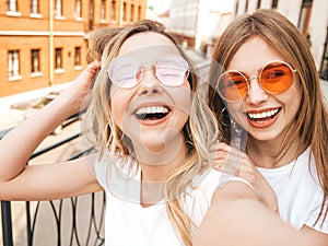 Two beautiful trendy girls posing in the street