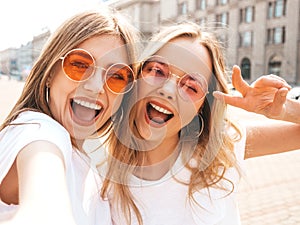 Two beautiful trendy girls posing in the street