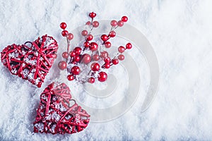 Two beautiful vintage red hearts with mistletoe berries on a white snow background. Christmas, love and St. Valentines Day concept