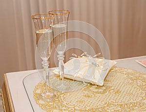 Two beautiful wedding glasses with champagne around the wedding ring