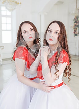 Two Beautiful woman in white and red medieval dresses with crinoline